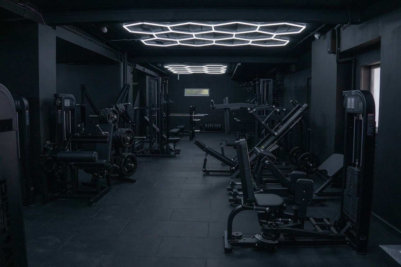 Barbell and bench press area with weight plates and power racks